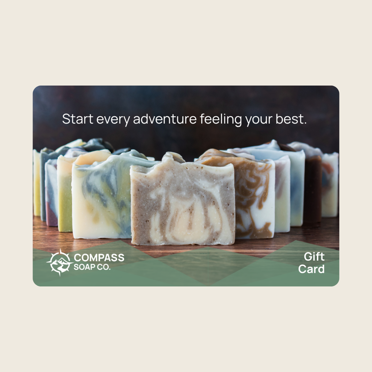 A Compass Soap Co. gift card featuring a photo of several marbled handmade soap bars on a wooden surface, with the text 'Start every adventure feeling your best.
